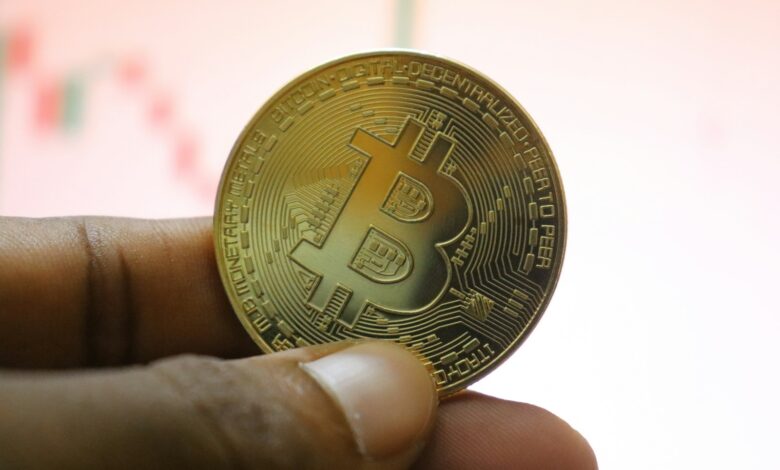 a person holding a bit coin in their hand