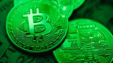 Close-up of green-illuminated Bitcoin coins representing digital currency and blockchain technology.