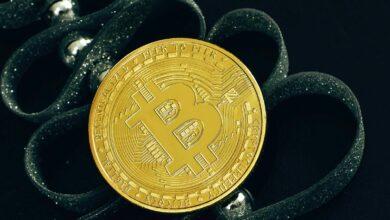 a bit coin sitting on top of a pair of scissors