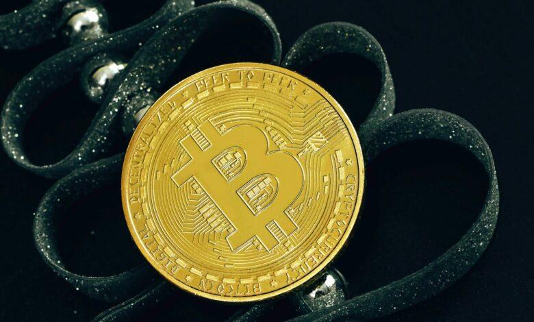 a bit coin sitting on top of a pair of scissors