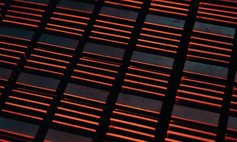 a close up of a metal grate with red lights