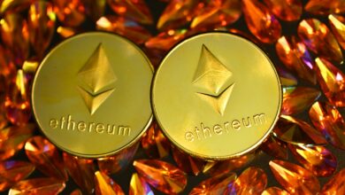 two gold ethereum tokens sitting on top of a pile of crystals