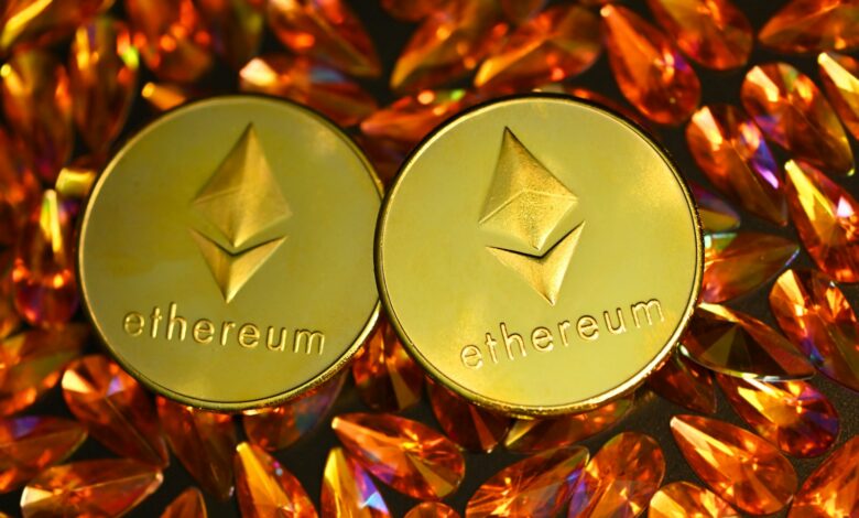 two gold ethereum tokens sitting on top of a pile of crystals